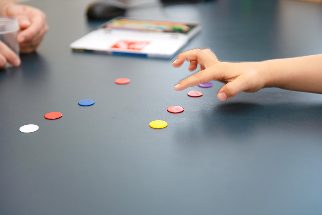 Vorsorgeuntersuchung Ein Kind zeigt auf farbige Buttons